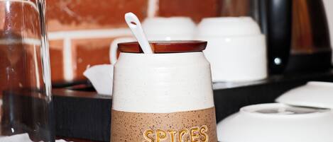 A kitchen counter with a spice jar labeled "SPICES" and a white kettle.