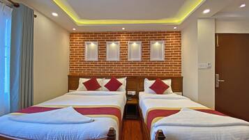 A hotel room with two beds, a brick wall, recessed lighting, and a wooden headboard.