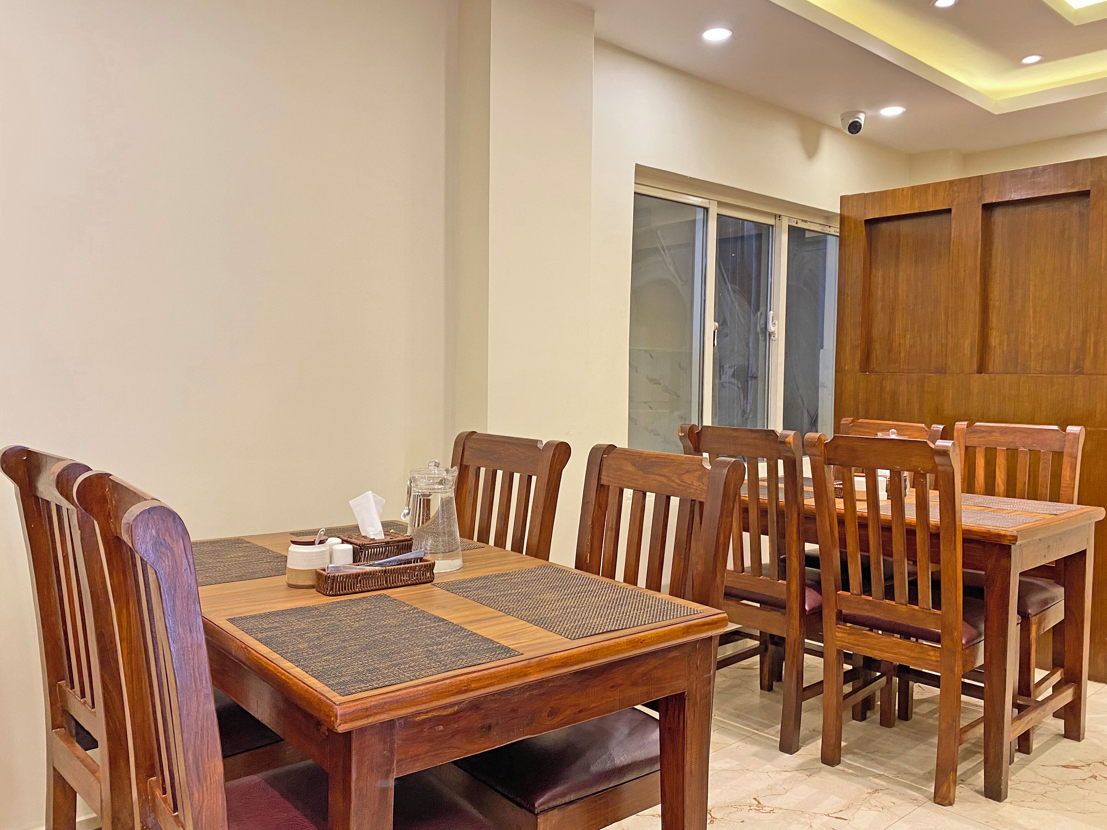 Un comedor con una mesa y sillas de madera, una jofaina y una cesta.