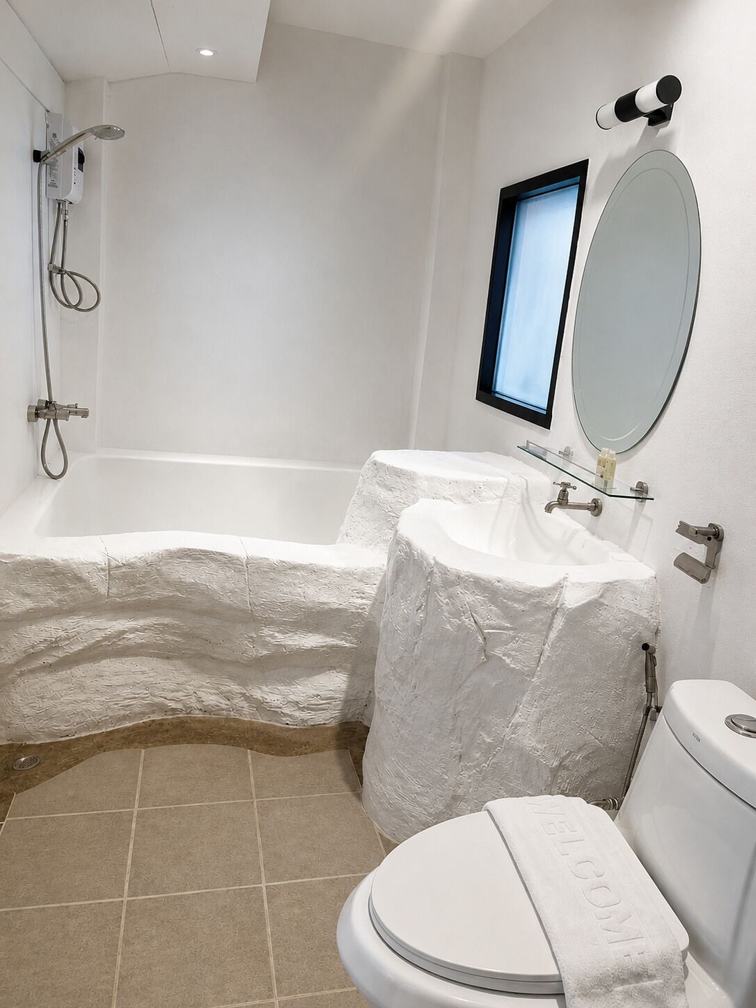 Un baño con bañera, inodoro y un espejo grande.