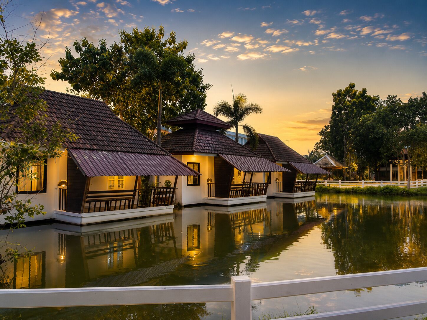 Una hilera de bungalows sobre el agua con una superficie acuática que refleja el paisaje.