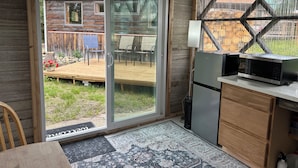 A compact kitchen with a microwave, a refrigerator, and a wooden cabinet. - 
Denali Haven: A Cosy Alaskan Retreat near Denali NP (Healy)
