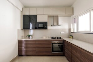 Uma cozinha moderna com micro-ondas embutido, forno e armários de madeira.