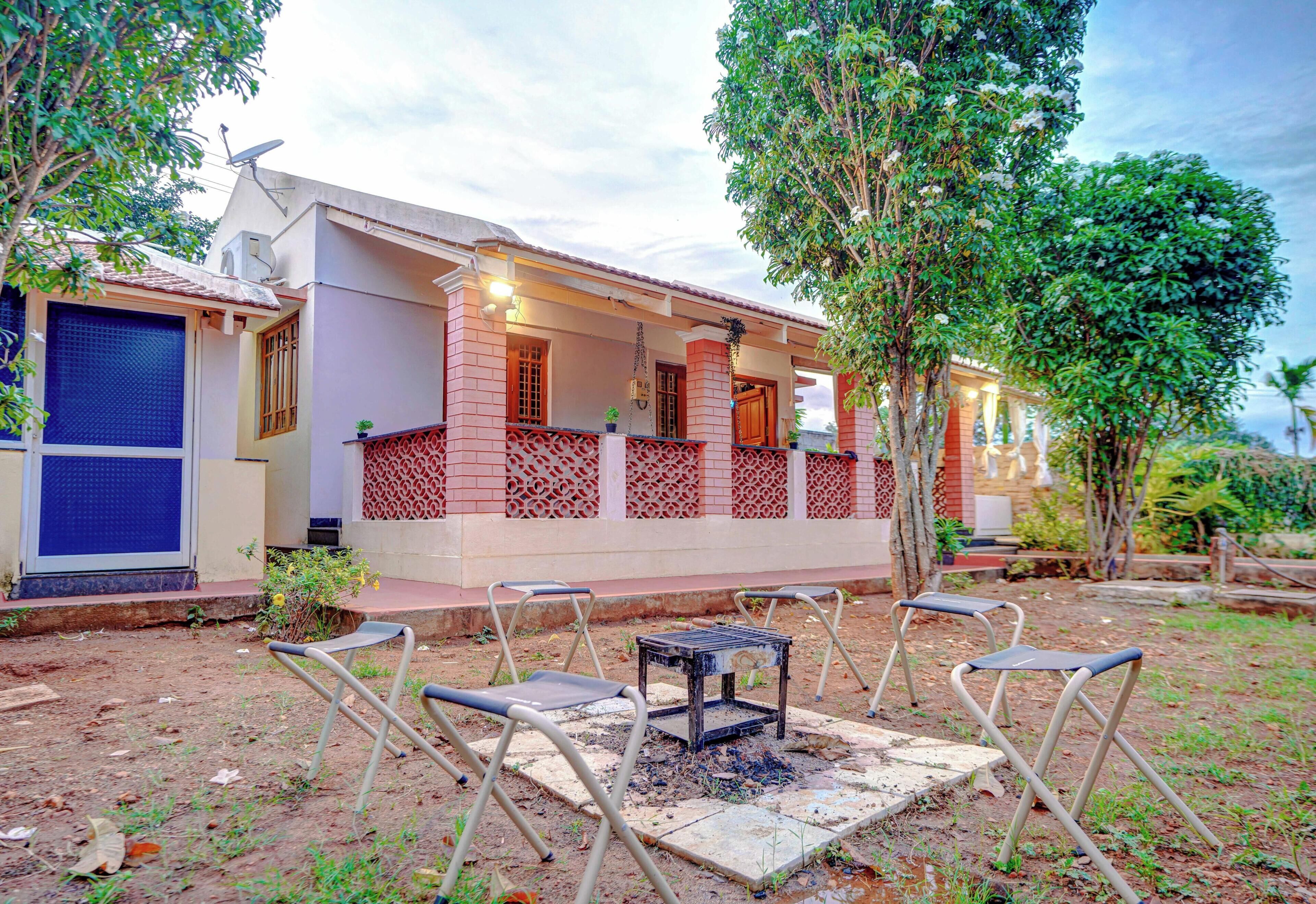 A house with a covered porch, outdoor seating, and a satellite dish.