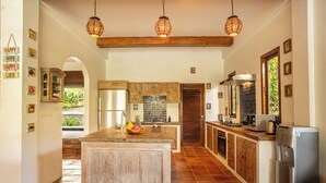 Una cocina amplia con una isla central, armarios de madera y un refrigerador de acero inoxidable.