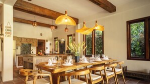 Comedor con una mesa de madera dispuesta para seis personas, rodeada de sillas de madera con asientos acolchados.