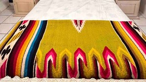 A bedroom with a bed, two nightstands, a dark wall, and a decorative wall hanging. - Charming 4-bedroom house with WiFi in Playas de Rosarito, secure gated parking (Playas de Rosarito)