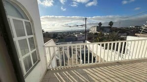 A balcony with a white railing overlooking a residential area. - Charming 4-bedroom house with WiFi in Playas de Rosarito, secure gated parking (Playas de Rosarito)