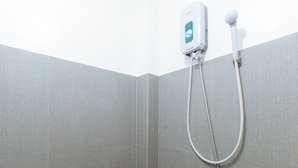 Een douche met een handdouche en een bedieningspaneel aan de muur.