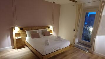 A bedroom with a wooden bed, bedside lamps, and a view of the outside.