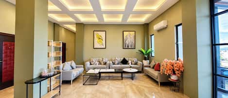 A modern living room with a sofa set, coffee table, and decorative plants.