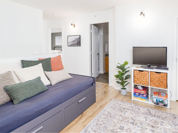 A modern living room with a sofa, TV, and storage unit.