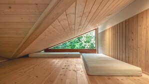 A room with a sloped wooden ceiling, a large window, and a wooden floor. - "Rosaline" - 500m from the sea by Interhome (Grenaa)