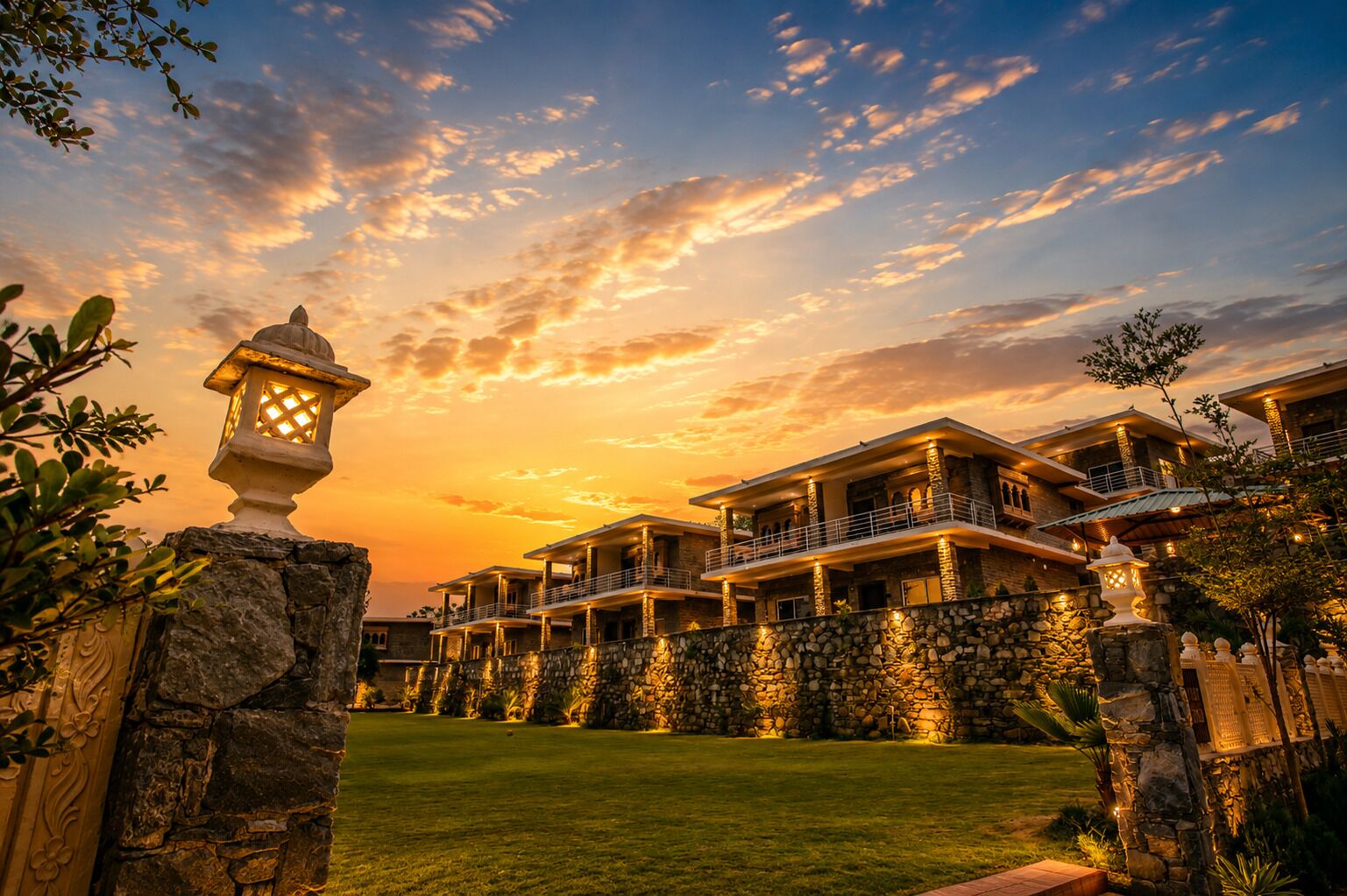 A multi-story hotel with a stone facade, multiple balconies, and a well-lit entrance.