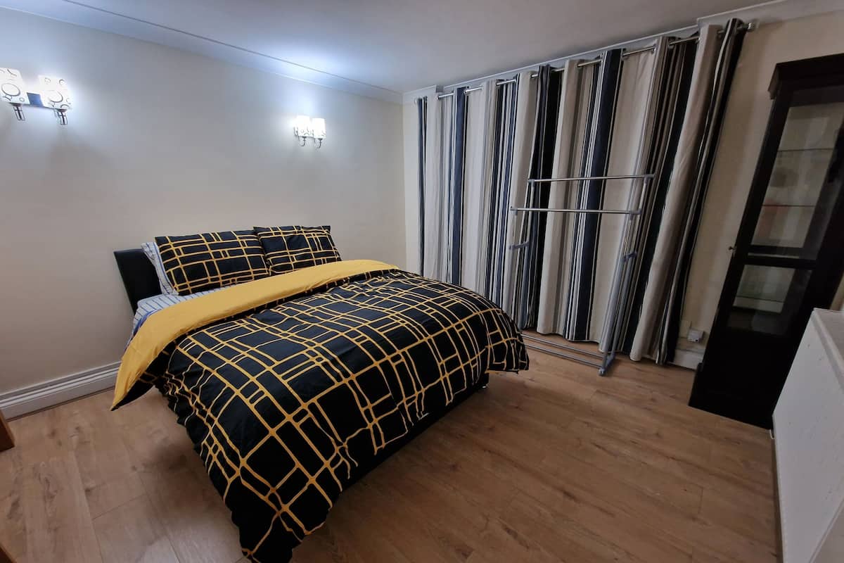Un dormitorio con cama, cortinas y un radiador.