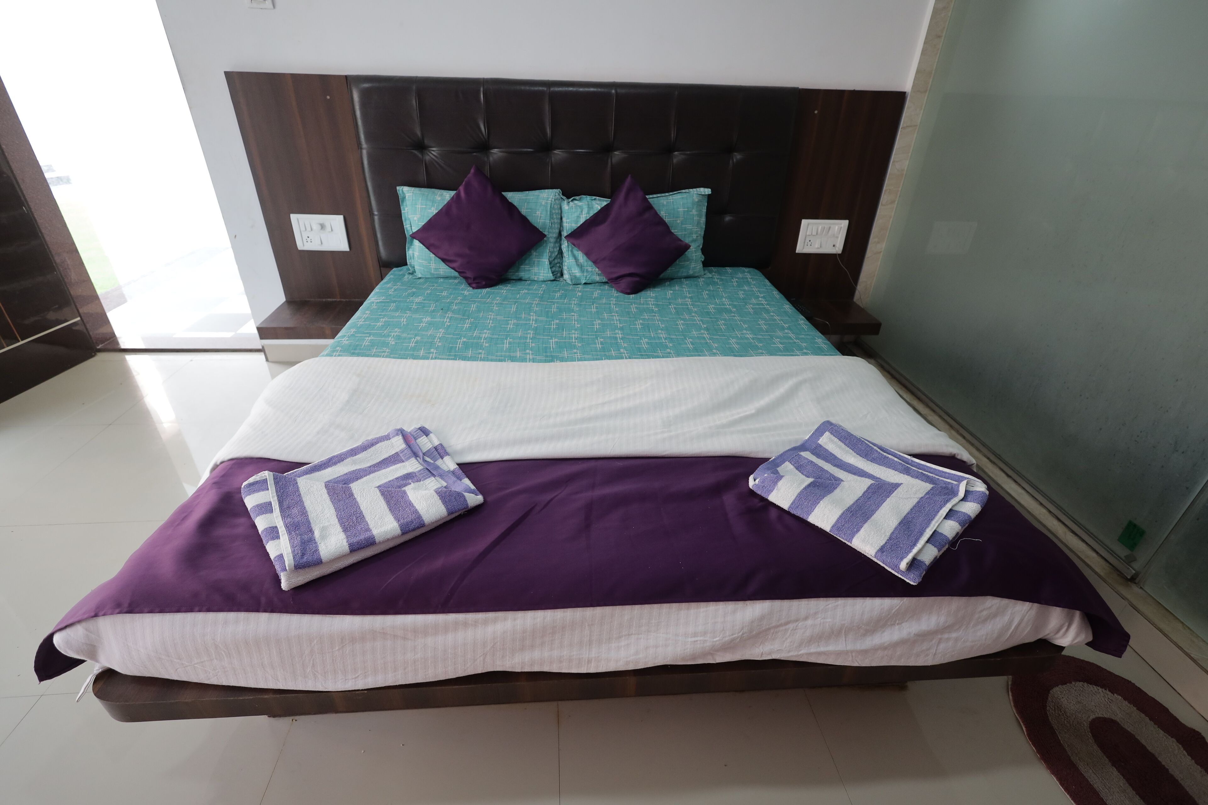 A bed with a headboard, two pillows, and a blanket.