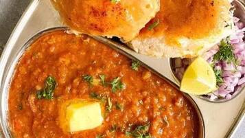 A meal consisting of a bowl of lentil soup garnished with butter and herbs, accompanied by two pieces of bread.