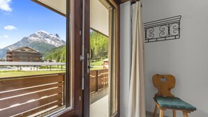 A balcony with a mountain view, a wooden chair, and a decorative wall piece. - View, 2 terraces & private parking - Saas-Grund (Saas-Grund)