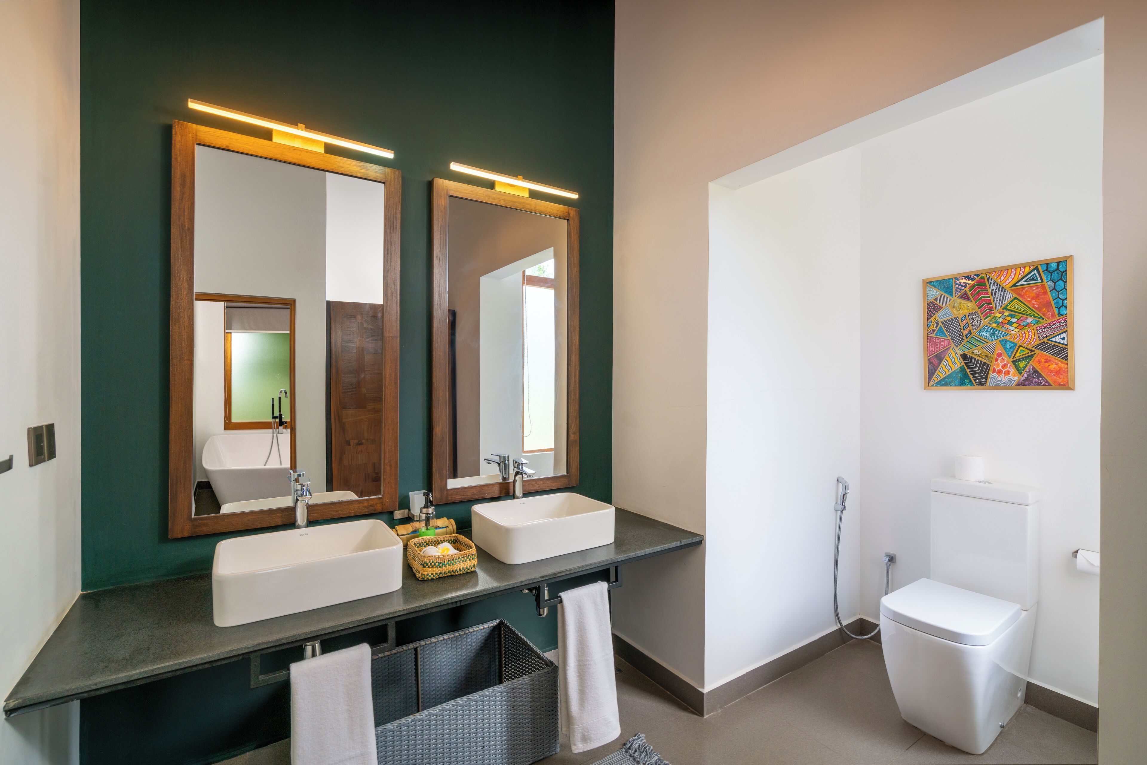 A modern bathroom with two sinks, a toilet, and a shower.