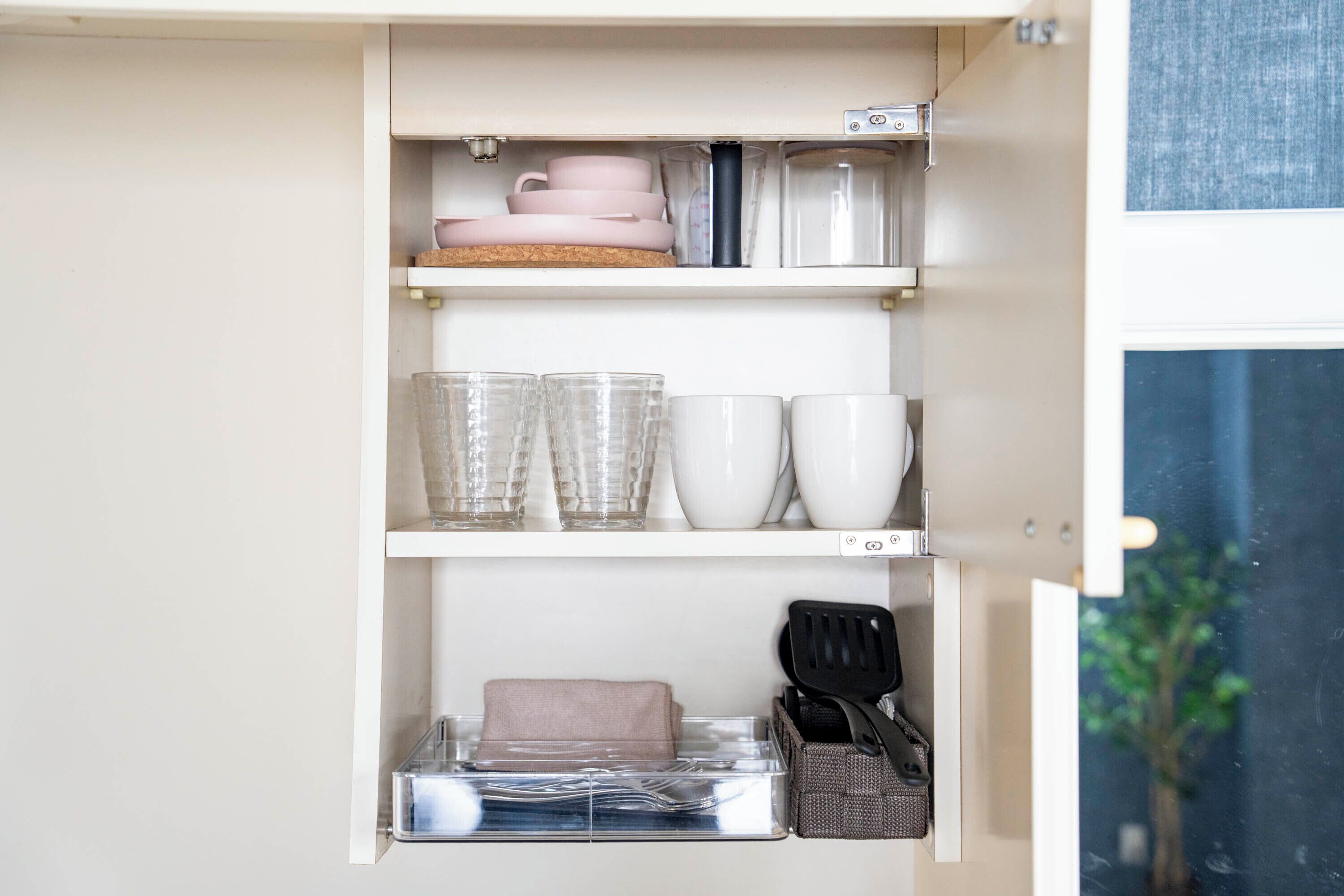 Ein Küchenschrank mit Geschirr, Gläsern und Besteck.