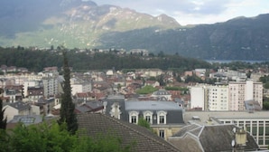 A town with buildings and mountains in the background. - Quiet studio, balcony with lake view, parking, near the spa, close to the center (aix les bains)