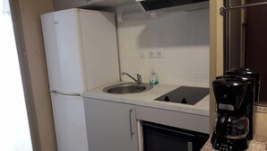 A compact kitchen with a refrigerator, sink, stove, and microwave. - Quiet studio, balcony with lake view, parking, near the spa, close to the center (aix les bains)