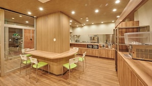 Una cucina moderna con mobili in legno, un'isola centrale con sedute e un frigorifero.