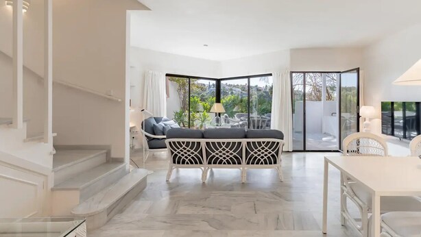 Ein modernes Interieur mit Sofa, Esstisch und Treppe.