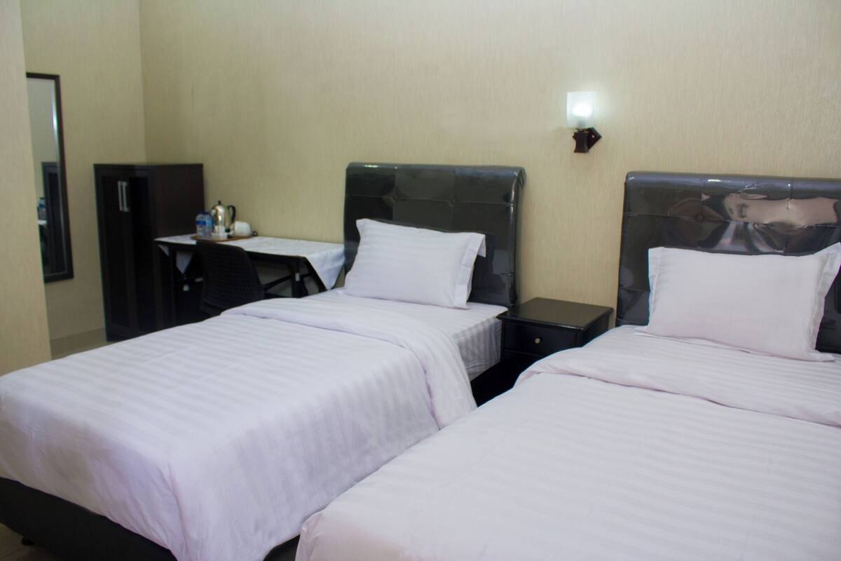 Una habitación de hotel con dos camas, un escritorio y una silla.