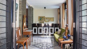 Un vestíbulo amplio con una mesa de recepción, un sofá verde y una lámpara decorativa.