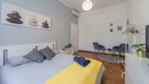 A modern bedroom with a bed, a desk, and a chair. - House Romana Center (Milano)
