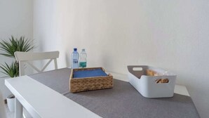 A small table with a woven basket and a grey storage box on a grey tablecloth. - House Romana Center (Milano)