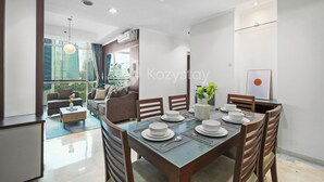 Un comedor moderno con una mesa de vidrio preparada para cuatro personas, rodeada de sillas de madera.