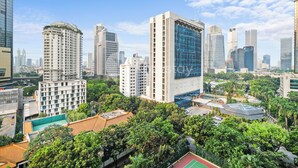 Un paisaje urbano con rascacielos, una combinación de edificios residenciales y comerciales, y zonas verdes.