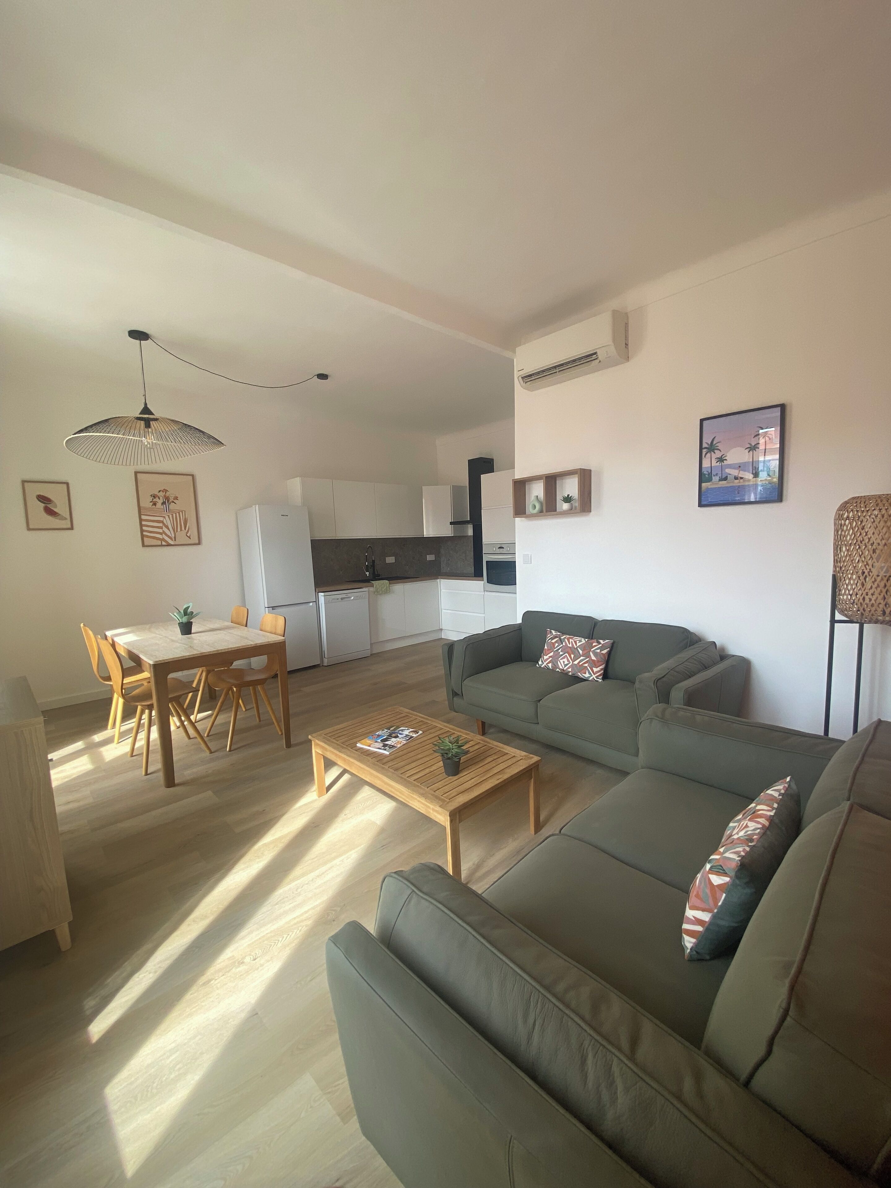 A modern living room with a sofa, coffee table, and dining area.