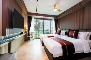 Habitación de hotel con cama, escritorio, silla, televisor y balcón con vistas.