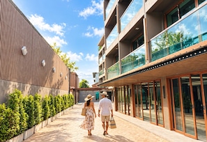 A modern building with a covered walkway, large windows, and a wooden facade. - The Legacy V Ao Nang Beach Krabi, an Aspira collection - Adults Only (Krabi)