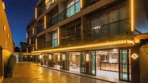 Un hotel de varios pisos con un amplio patio, puertas de cristal y una zona de recepción.