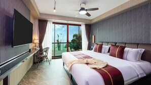 Una habitación de hotel con una cama grande, un televisor de pantalla plana, un escritorio con una silla y un balcón con vistas a palmeras.