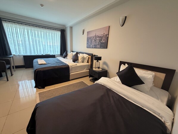 Una habitación de hotel con dos camas, un escritorio y una silla.