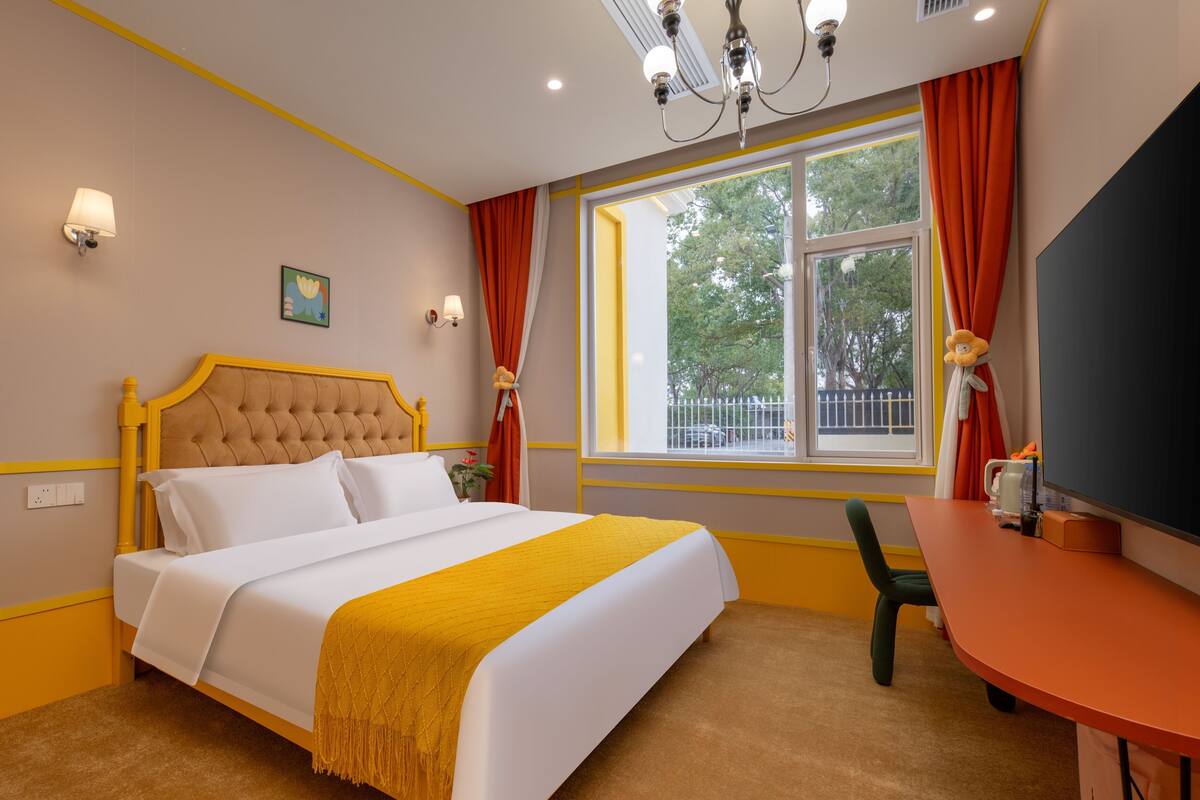 A neatly arranged bedroom with a bed, a desk, and a chair.