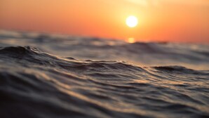 A sunset over the ocean with waves.