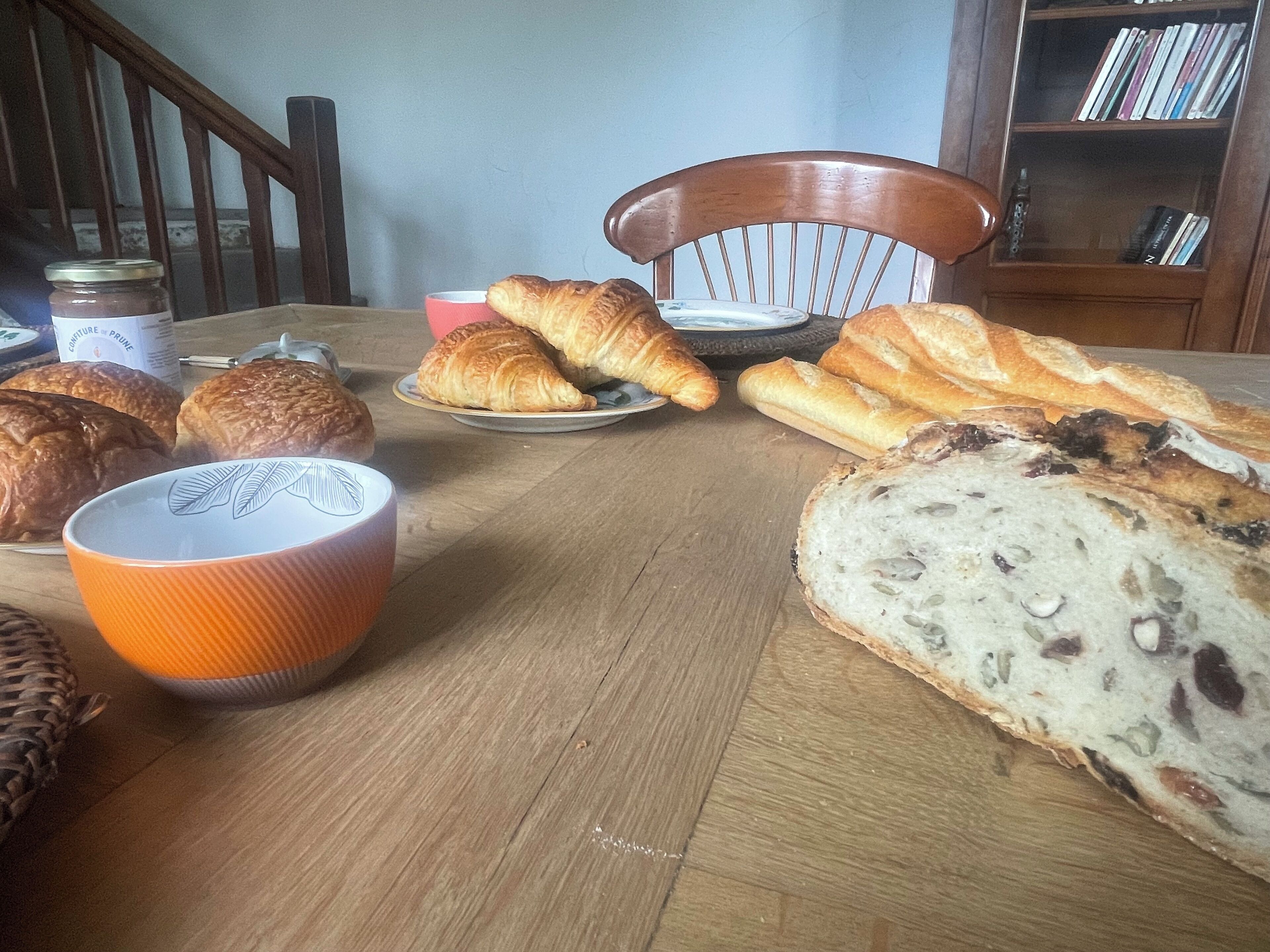 Een eettafel met verschillende soorten brood en een kopje.