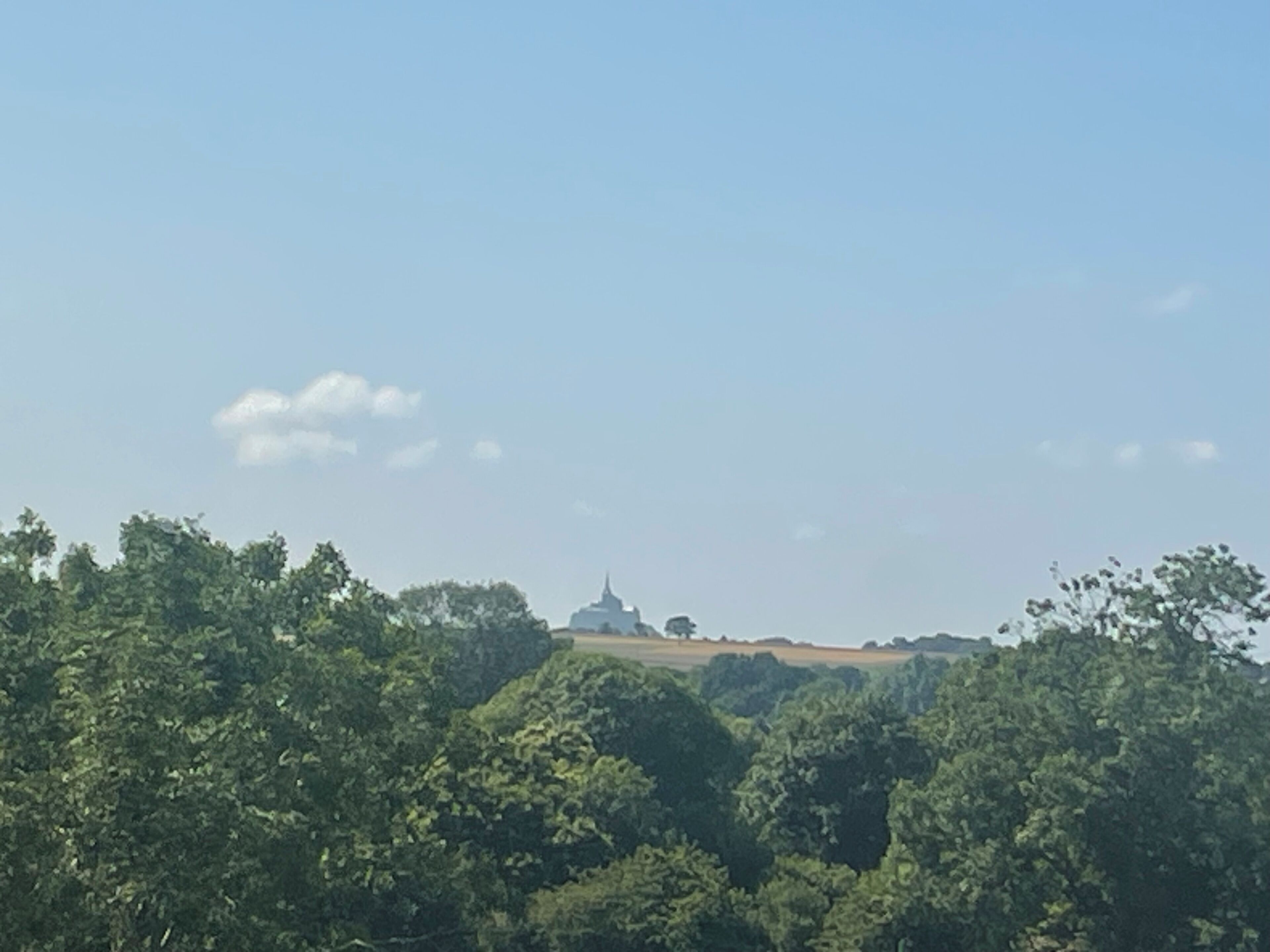 A landscape with a prominent hill and a temple-like structure in the distance.