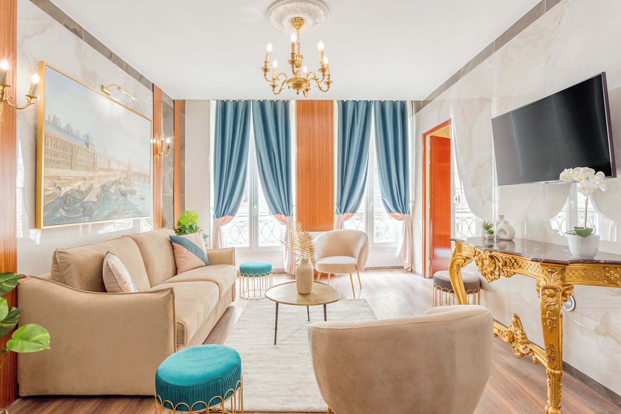 A spacious living room with a sofa, armchairs, a coffee table, and a TV.