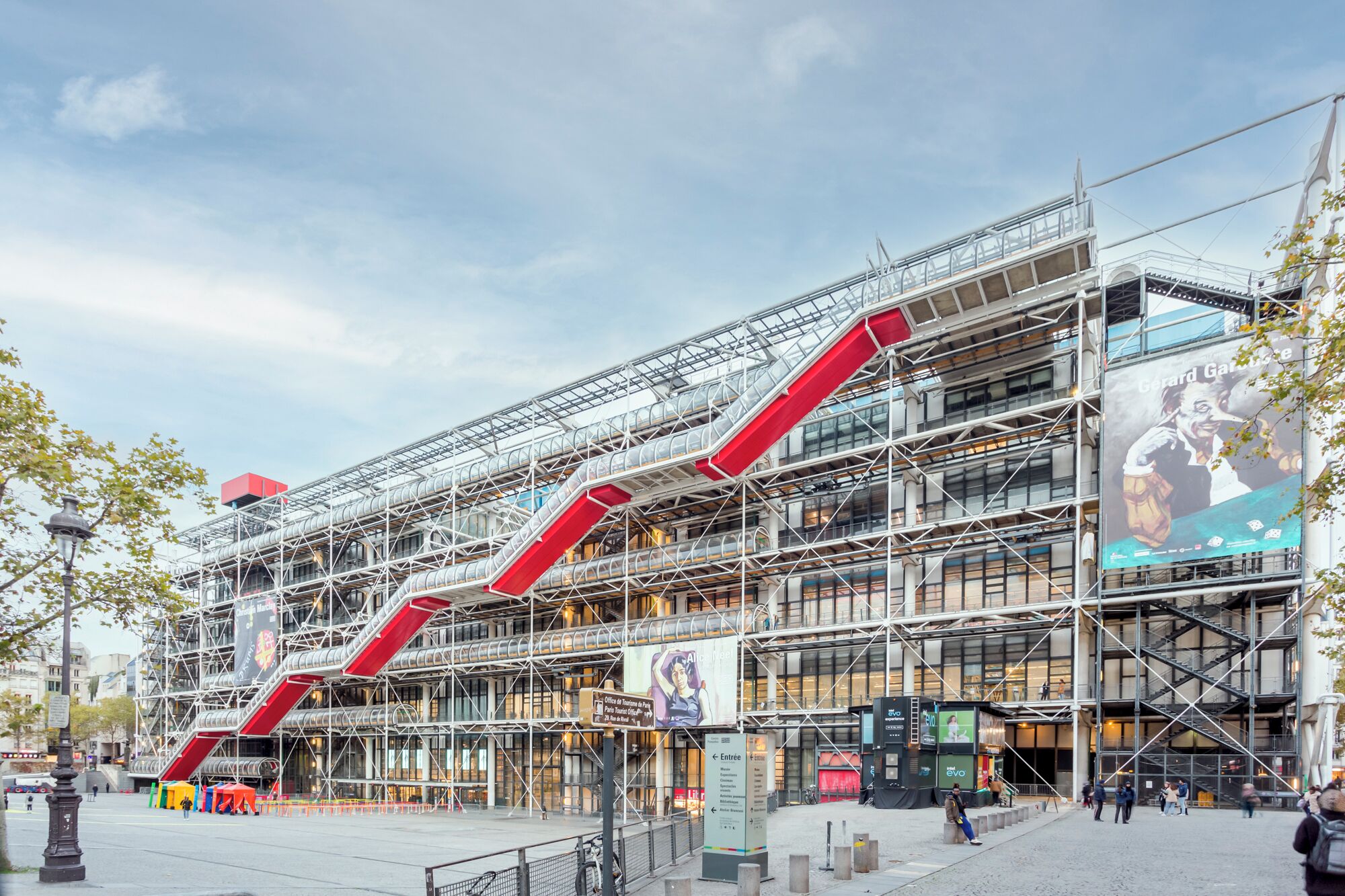 A modern building with multiple levels and red staircases.