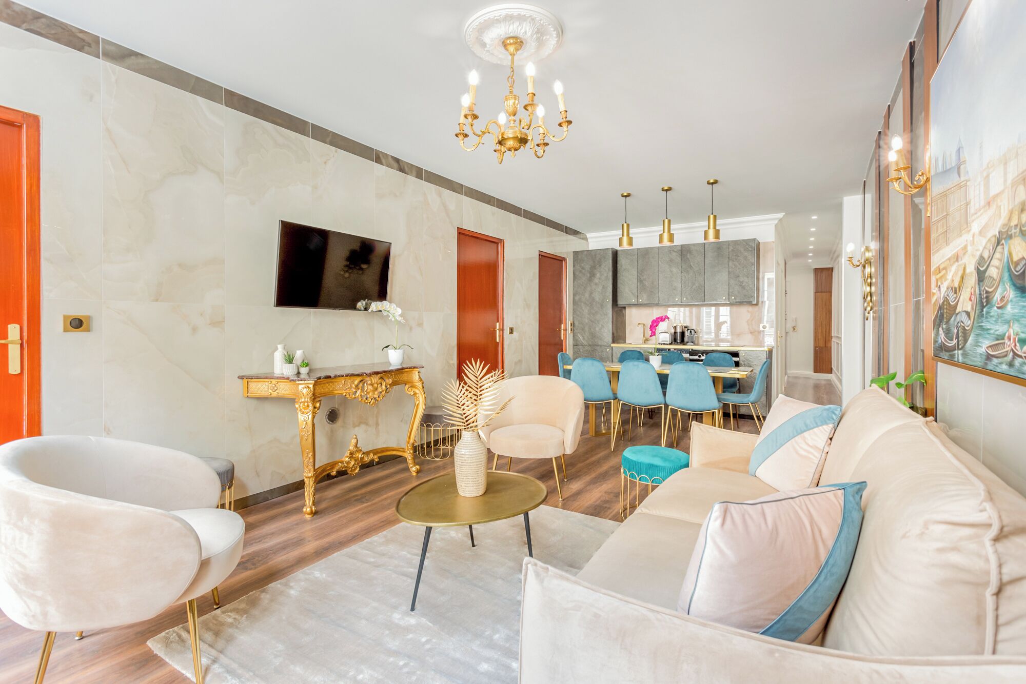 A spacious living room with a sofa, armchairs, a coffee table, and a TV.