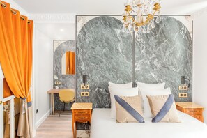 Ein modernes Schlafzimmer mit einem großen Bett, Marmorwand und einer Chandelüster.