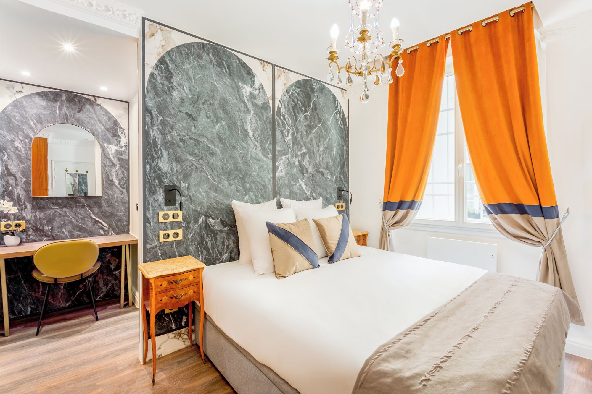 Une chambre à coucher moderne avec un grand lit, un bureau et un miroir.