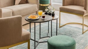 A living room with a beige sofa, two armchairs, a round coffee table, and a chandelier. - Merveil Luxury Suites - Marais - Martin I-II (Paris)